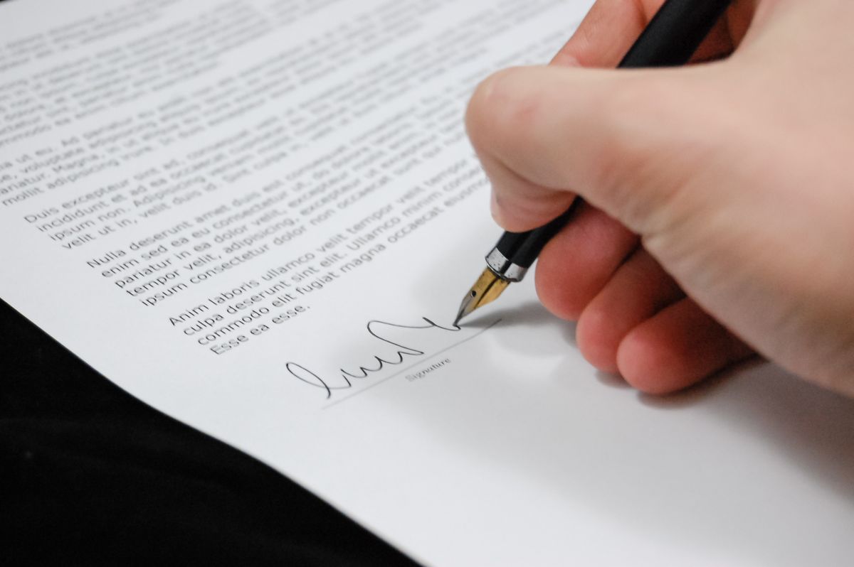 Person signing legal rental documents at a desk