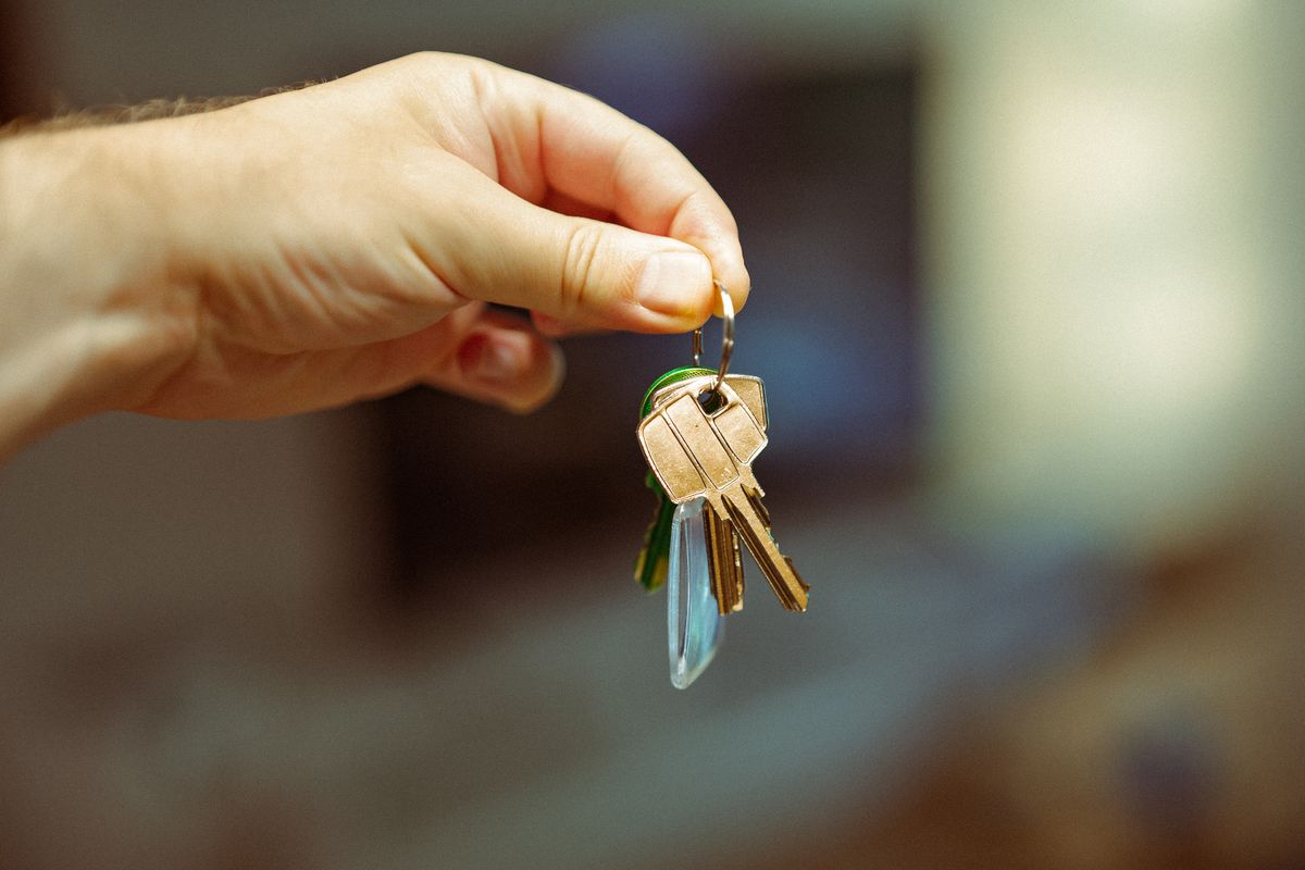 Apartment keys on a table beside a lease folder